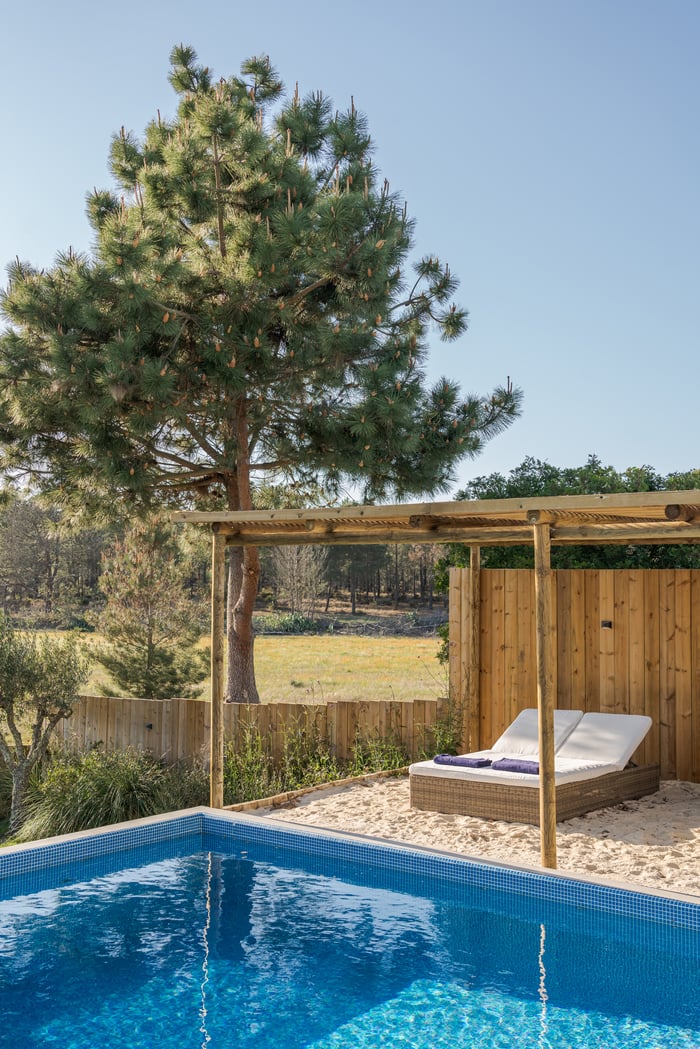 A private outdoor pool surrounded by pine trees